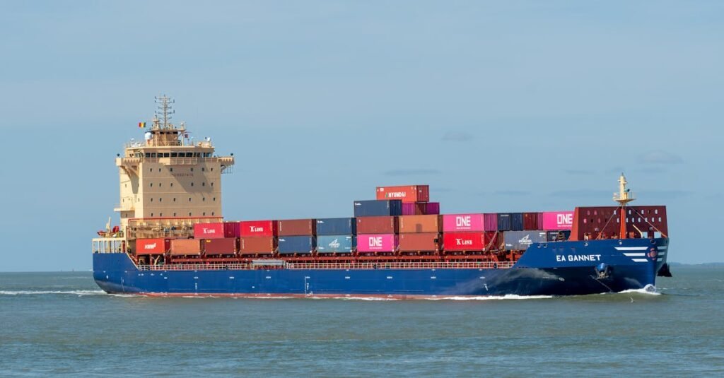 A cargo ship transporting colorful containers across a calm sea on a clear day.